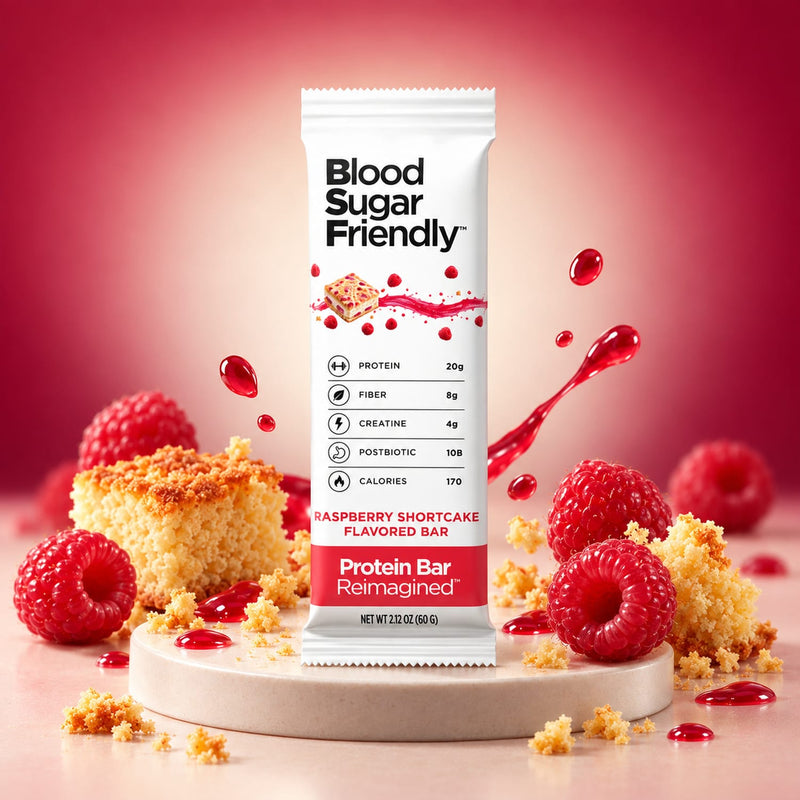 Protein Bar Reimagined™ Raspberry Shortcake bar on a round pedestal with raspberries and shortcake crumbs